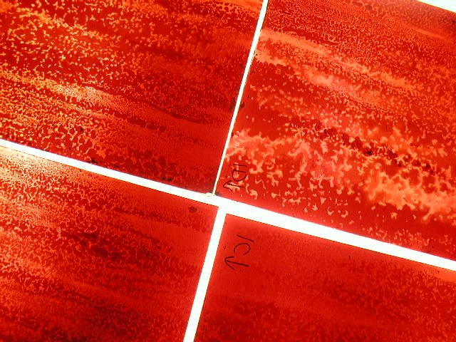 Earth window — deep red flashed glass, volcanic surface